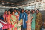 A group of women posing together inside a community meeting space.