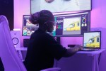 Person working with multiple AI-assisted digital systems and computer screens.